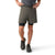 Wearing a grey tee, Smartwool Mens Intraknit Active Lined 5 Inch Shorts in olive over black compression shorts, and grey running shoes, a person stands with one hand on their hip and the other resting on their thigh.