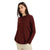 A woman with long dark hair wears the Icebreaker Women's Nova Sweater Sweatshirt in maroon with beige pants, standing with her hands in her pockets against a plain white background.