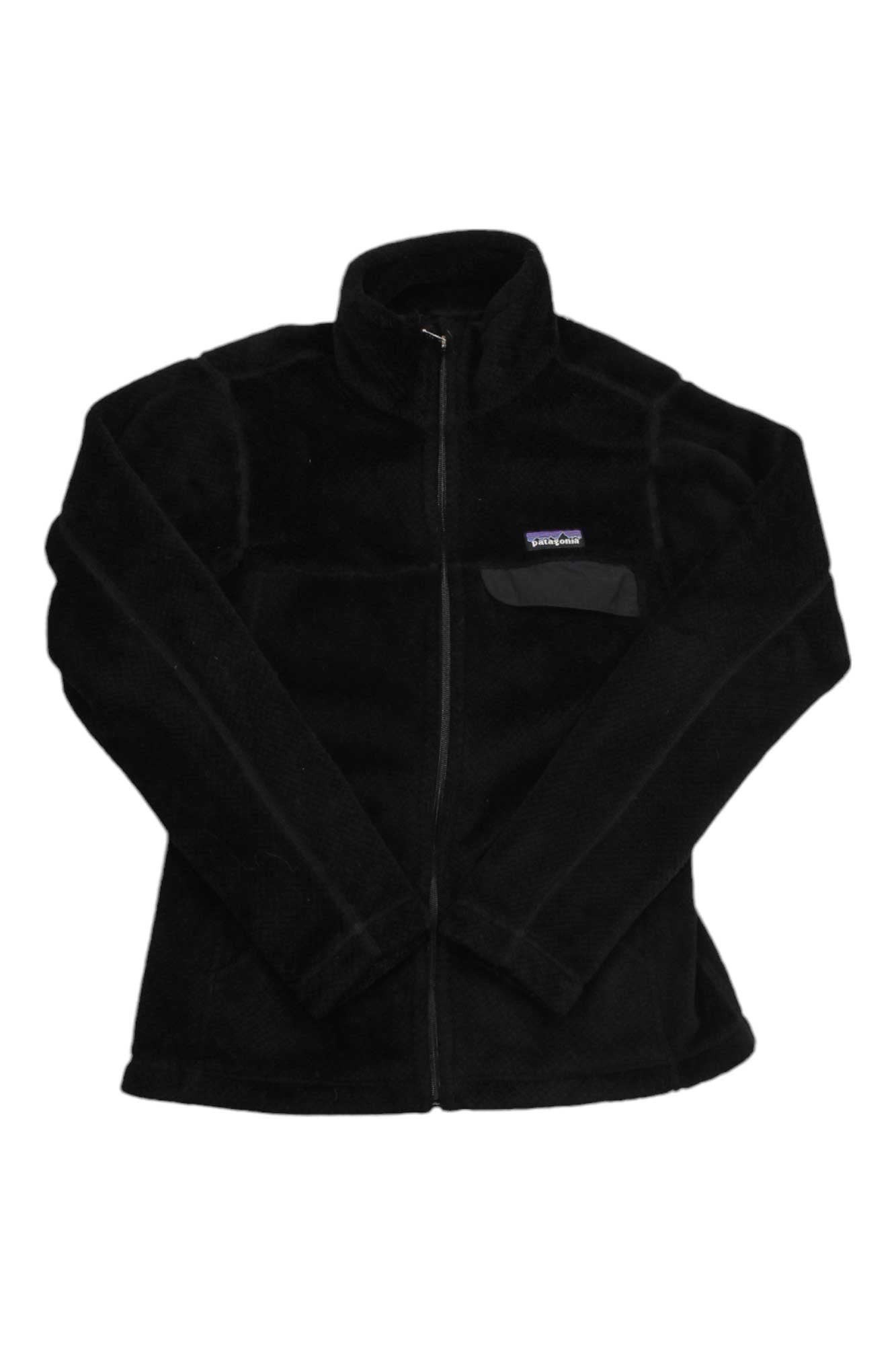 The Women's Full-Zip Re-Tool Jacket by Patagonia is black Polartec Thermal Pro fleece with a front zipper, high collar, and small logo chest pocket, shown laid flat on a white background.