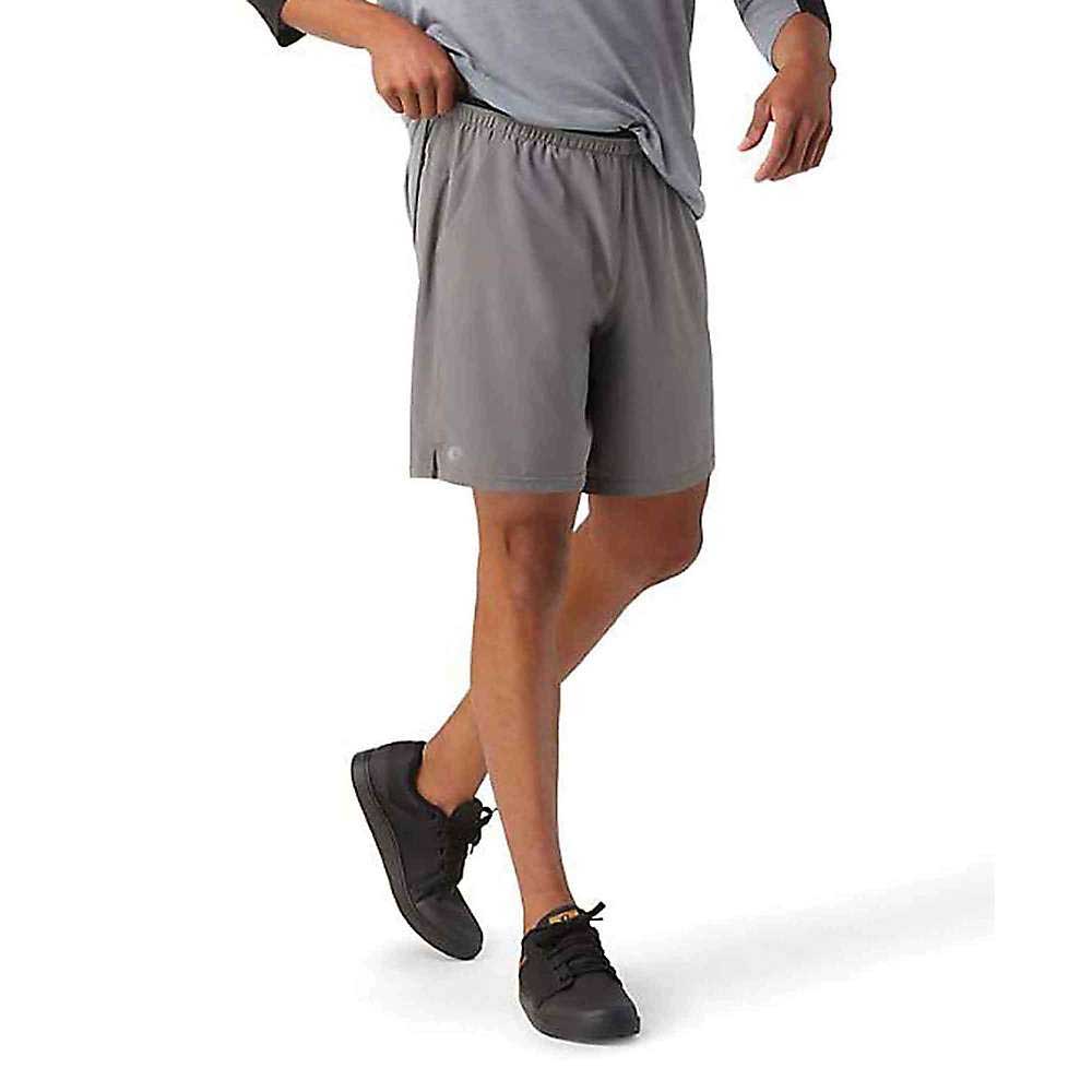 A person in a gray long-sleeve shirt, Smartwool Men's Active Lined 8 Inch Shorts, and black sneakers walks against a white background. Their head and upper torso are out of the frame.