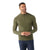A man in a fitted, olive green Smartwool Men's Sparwood Half Zip Sweater and dark blue jeans stands smiling with his hands loosely clasped before him against a plain white background.