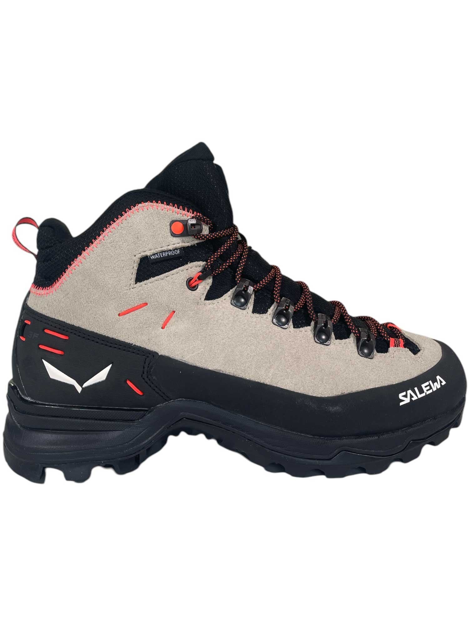 The Salewa Womens Alp Mate Winter Mid Waterproof Boot is a beige and black hiking boot with red accents, black laces with red details, a rugged sole, and the Salewa logo on the side—ideal for women’s mountaineering.