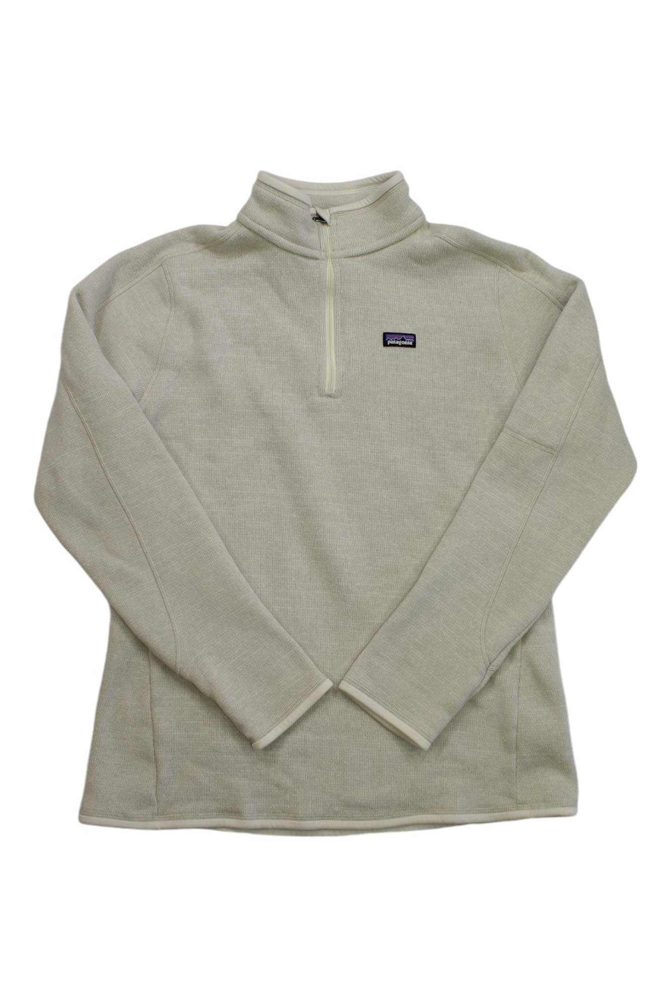 The Womens Better Sweater 1/4-Zip is a light beige, long-sleeve fleece pullover with a quarter-zip, small left chest logo patch, and zippered security pocket; hip length and displayed flat on a white background.