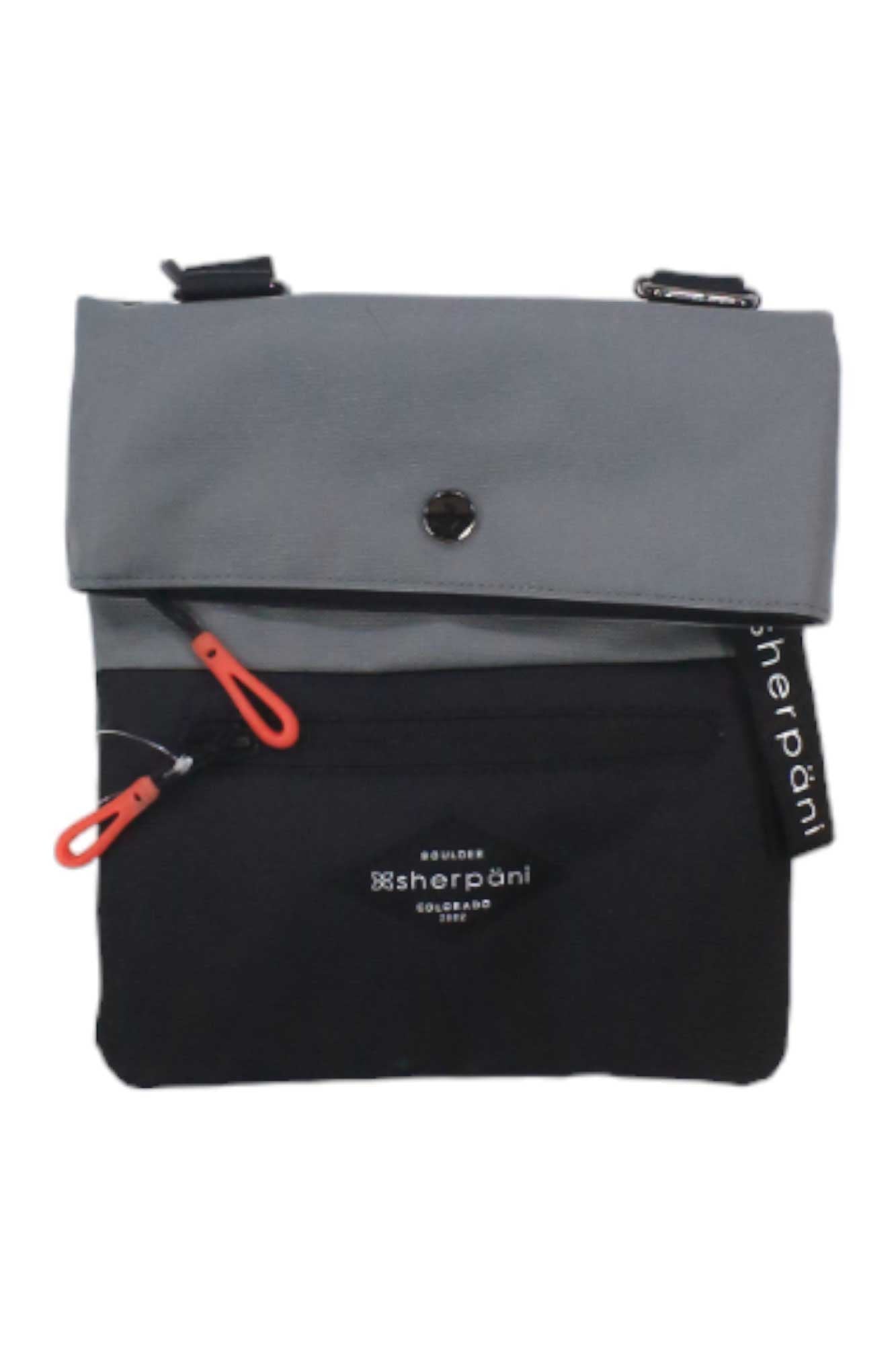 The Sherpani Womens Pica Cross Body Bag features a gray snap-button flap over a black body, front zipper pockets with red pulls, and is made from recycled materials. It displays the Sherpani logo and tag.
