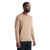 A man stands against a plain white background, wearing the Icebreaker Men's Wilcox LS V Neck Sweater in beige and black pants, facing slightly to the side with a neutral expression.