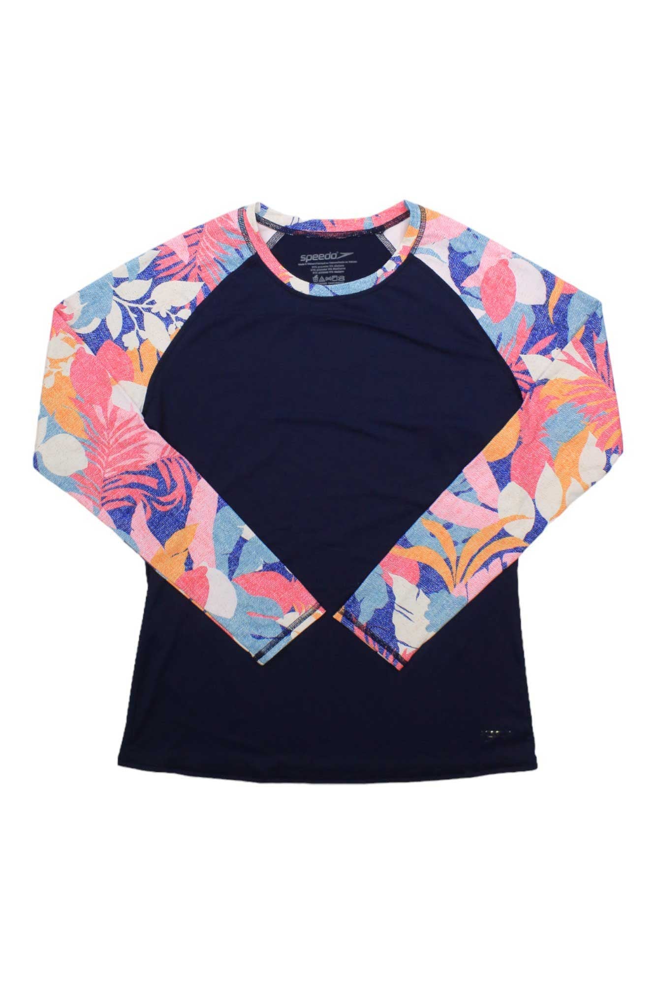 The Speedo Women's Printed LS Rashguard features a sun-protective dark blue body with vibrant floral-patterned long sleeves and round neckline in pink, blue, orange, and white.
