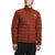 A person stands against a plain white background wearing The North Face Mens Belleview Stretch Down Jacket in rust, featuring recycled down insulation and a front zipper, paired with black pants.