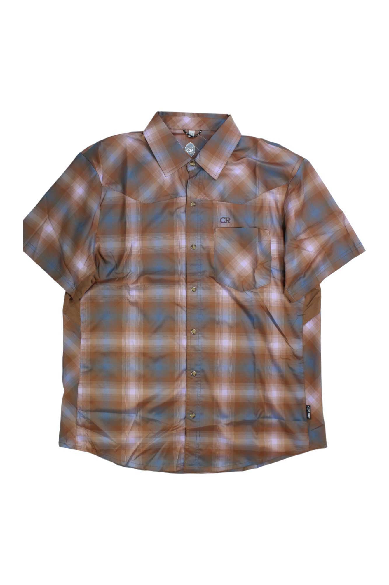 The Club Ride Mens New West Shirt is a short-sleeve, button-up cycling shirt in brown, blue, and white plaid with a collar, left chest pocket, and UPF 50 moisture-wicking fabric, shown on a plain white background.
