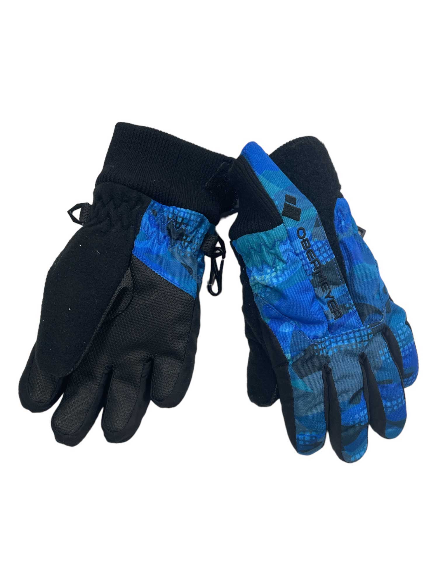 The Obermeyer Kids Thumbs Up Glove - Printed features black palms, blue patterned backs, ribbed cuffs, and the Obermeyer logo on one glove—ideal insulated ski gloves for kids, shown against a white background.