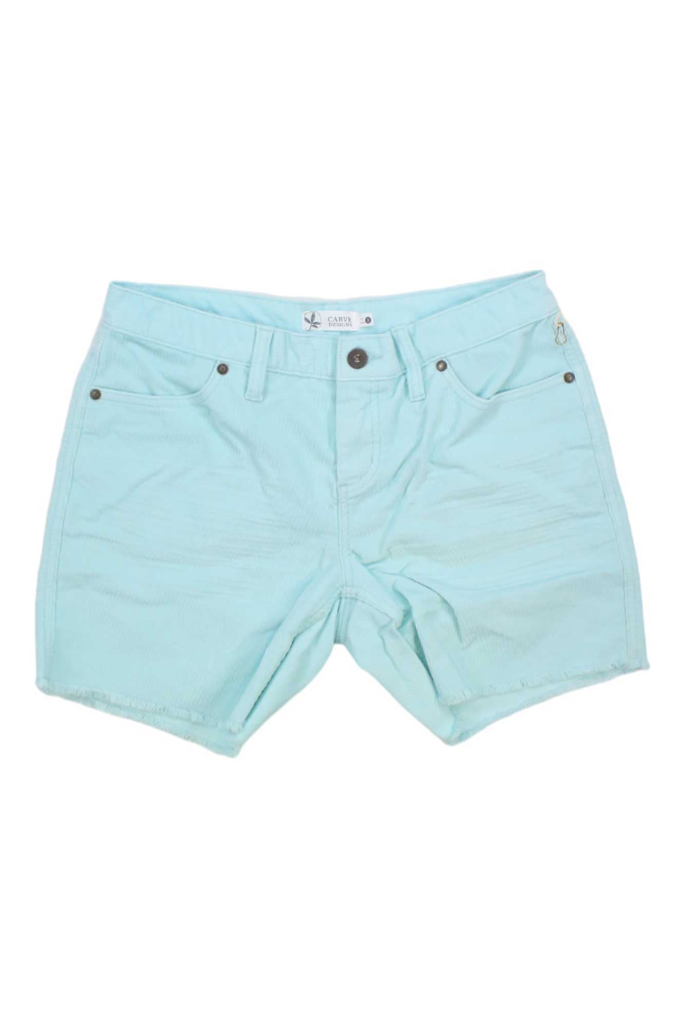 Carve Designs Womens Oahu 6 Inch Short in light blue, made from organic cotton with front and back pockets, button closure, and raw hems, shown laid flat on a white background.