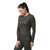 A woman with a ponytail wears the Smartwool Womens Intraknit Thermal Merino Base Layer Crew and matching leggings, standing against a plain white background and looking down with a slight smile.