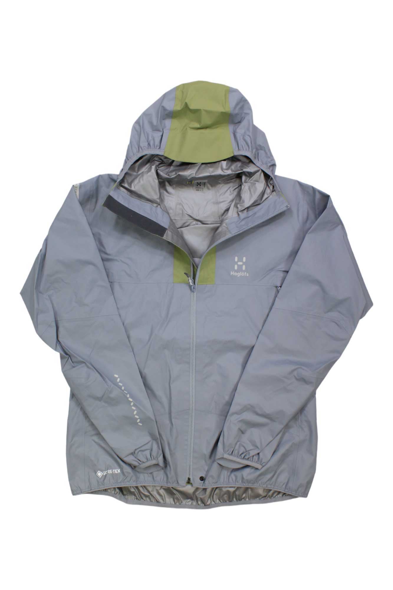 The Haglofs Womens L.I.M GTX Jacket is a light gray hiking jacket with a front zipper, olive green accents on the hood and chest, reflective logos, and features lightweight, waterproof, durable, and breathable material.