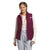A young woman with braided hair wears The North Face Womens Shady Glade Insulated Vest, featuring recycled polyester and Heatseeker Eco insulation, over a white long-sleeve shirt and light gray pants against a plain white background.