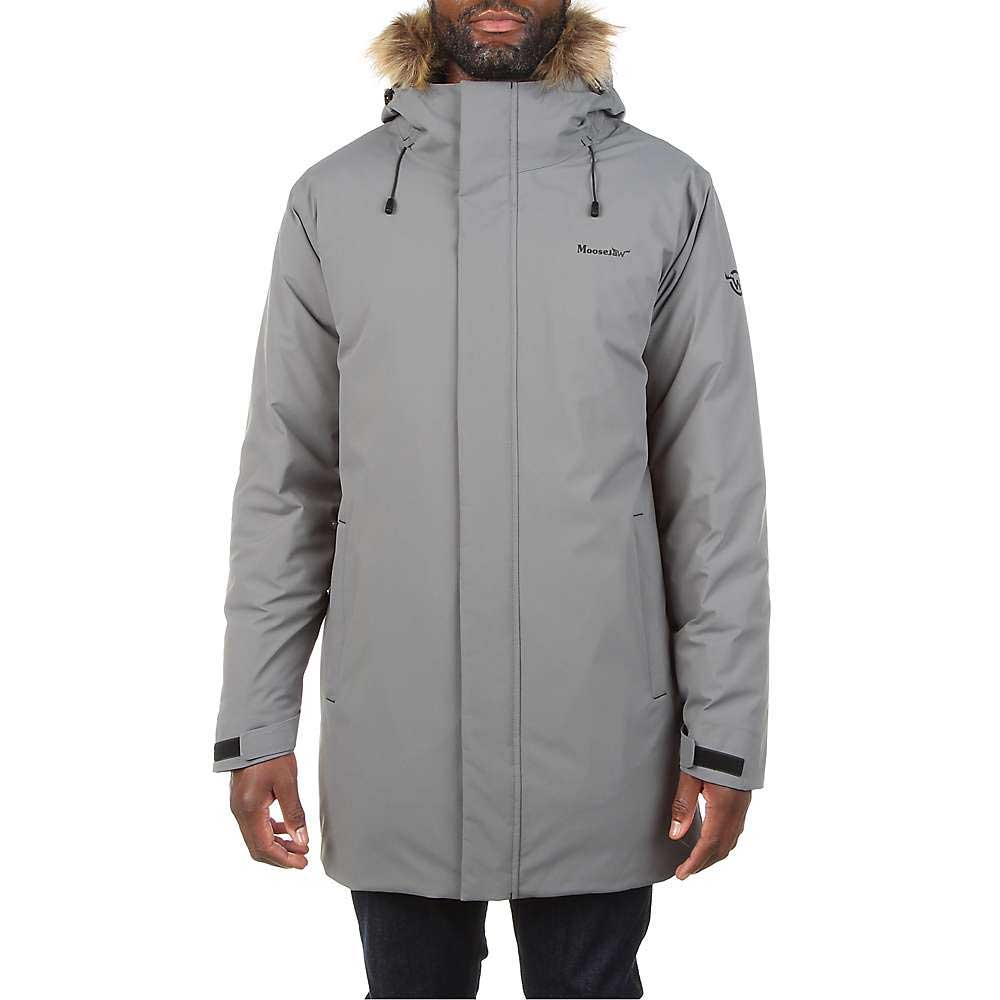 A man wears the Moosejaw Men's Hooded Down Parka in light gray, featuring a fur-trimmed hood, high collar, front zipper, velcro cuffs, and insulated design. Only his lower face and hands are visible.
