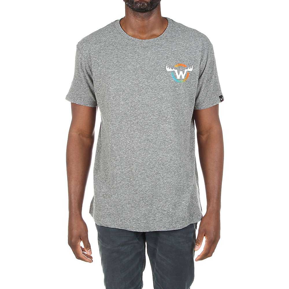 A man stands against a white background wearing the Moosejaw Mens Fearsome Critter SS Tee in heather gray, featuring a small moose and "W" graphic on the left chest, paired with dark pants.