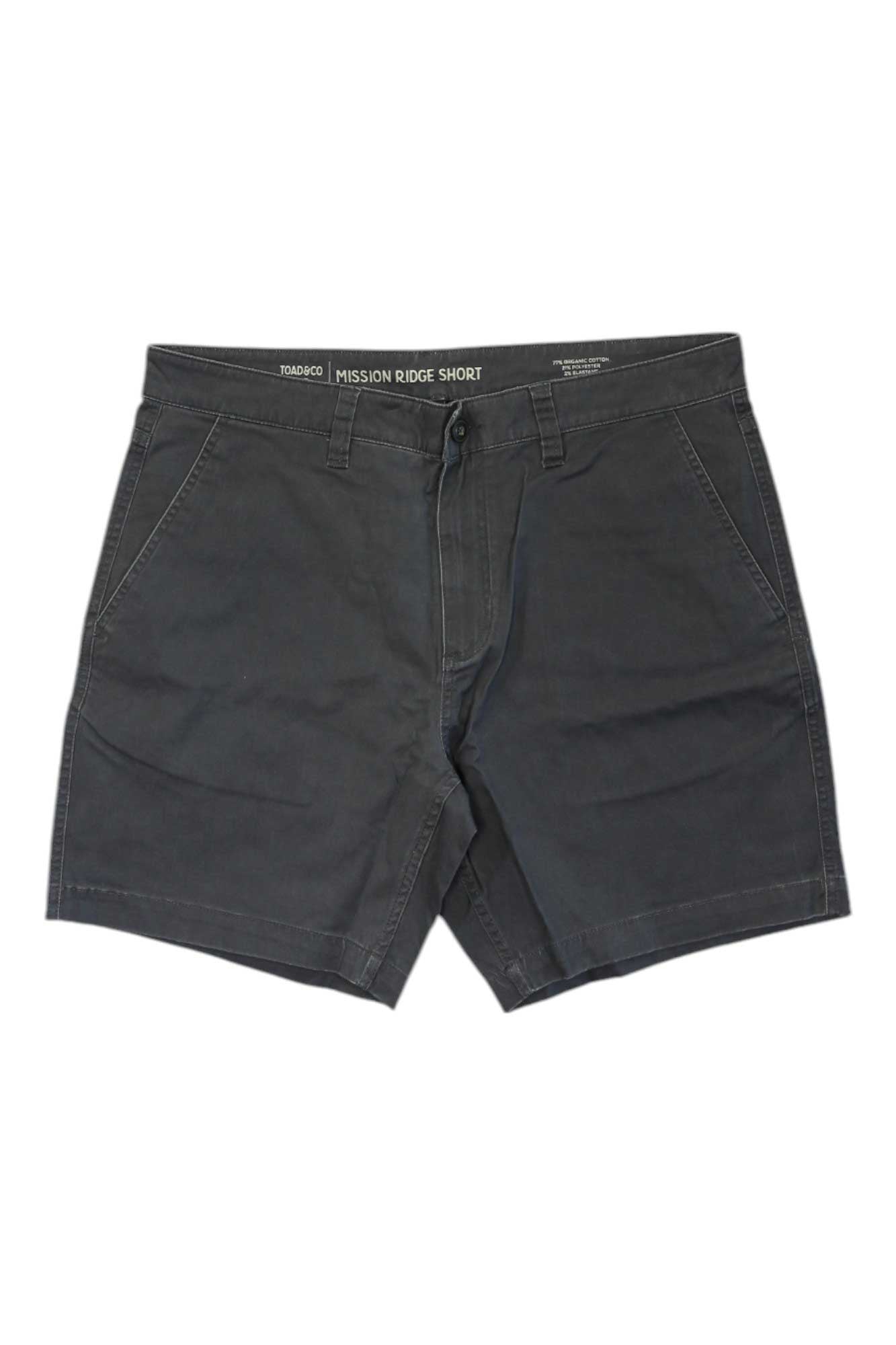The Toad & Co Men's Mission Ridge 8 Inch Short is a pair of dark gray sun-protective shorts with front pockets, button and zipper closure, and belt loops—ideal for hiking in comfort and style.