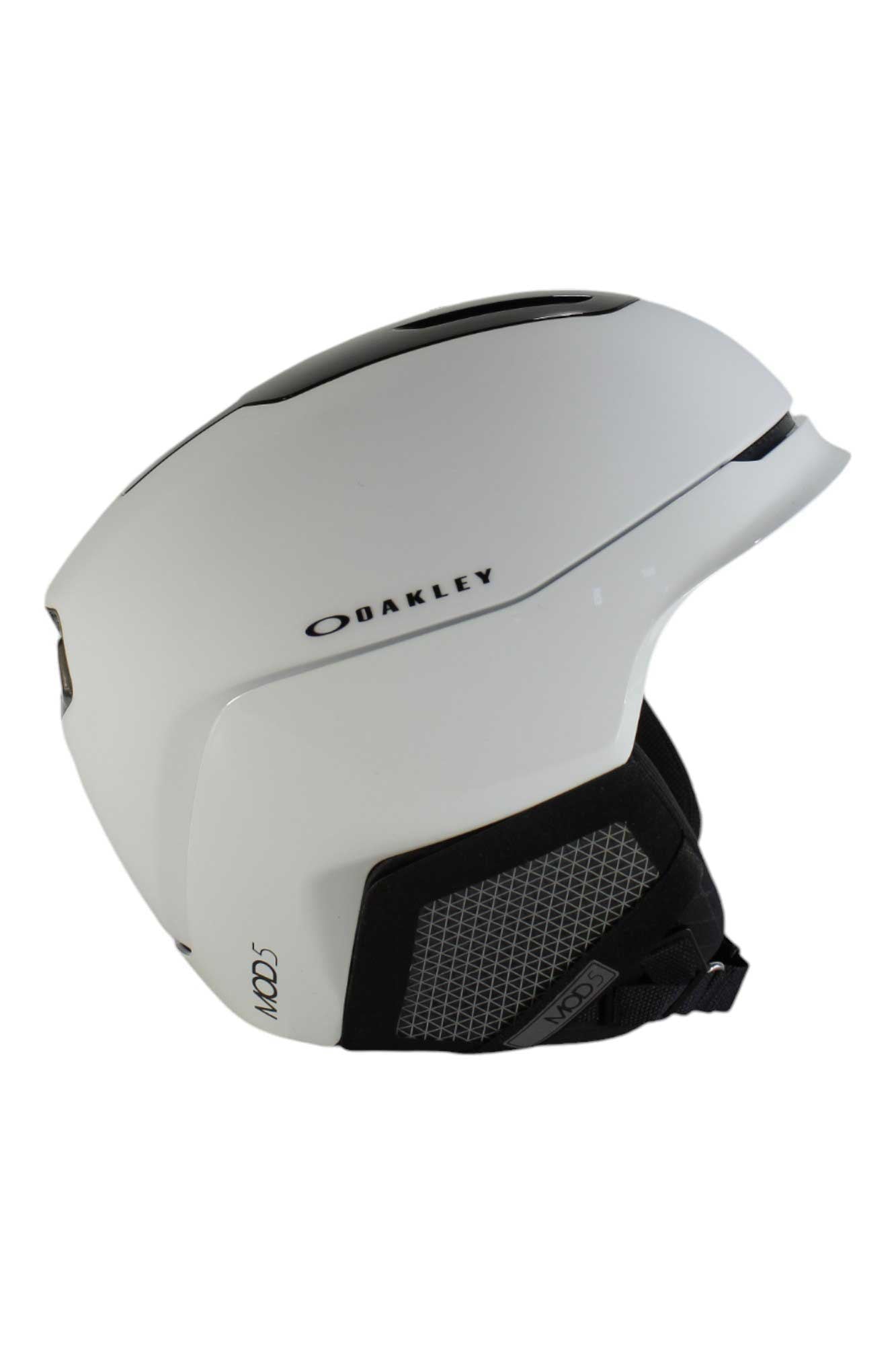 The Oakley Mod 5 Helmet in white features black and gray accents, side vents for adjustable airflow, a chin strap, and is designed for seamless goggle integration—shown on a plain background.