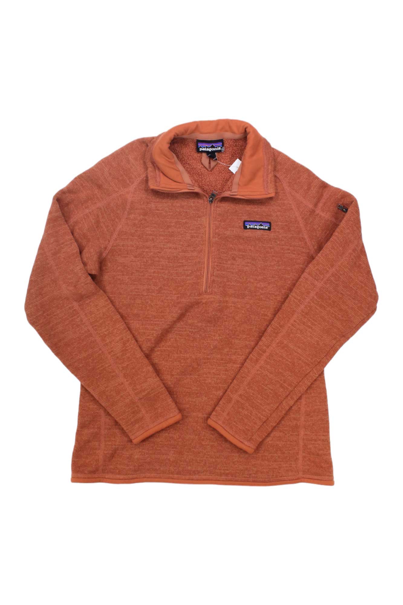 The Women's Better Sweater Quarter-Zip Pullover by Patagonia is shown in burnt orange, made from recycled polyester fleece with long sleeves and a small logo patch on the left chest, laid flat on a white background.
