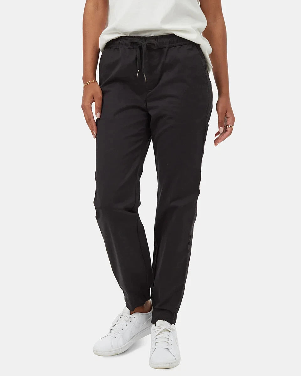 A person wearing Tentree Womens Pacific Regular Fit Jogger pants, a white shirt, and white sneakers stands against a plain white background, with only the lower half of the body visible.