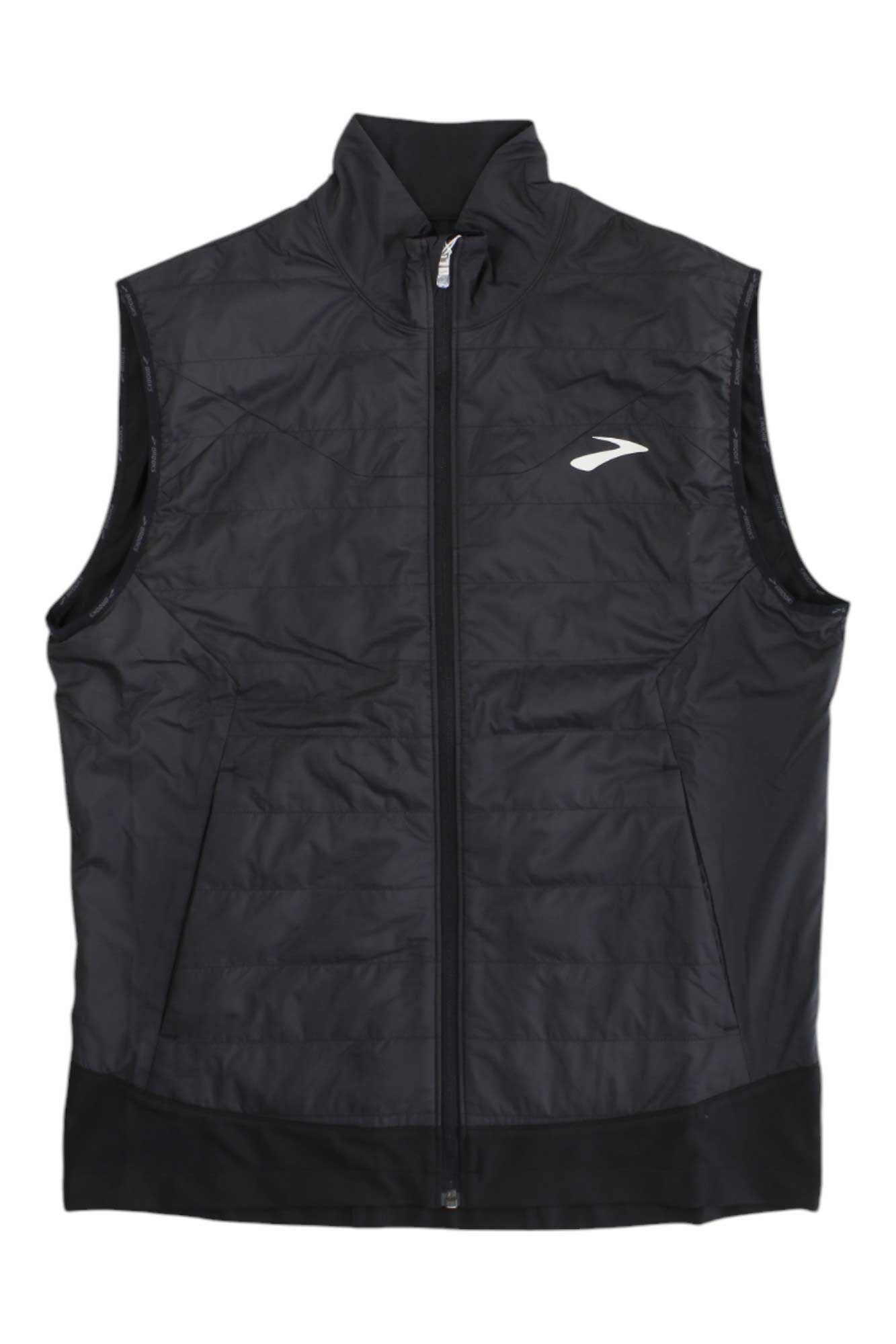 The Brooks Mens Shield Hybrid 2.0 Vest is a black, sleeveless zip-up with a high collar and small white left-chest logo. Its quilted design makes it perfect for outdoor use, and it has no visible pockets for a streamlined look.