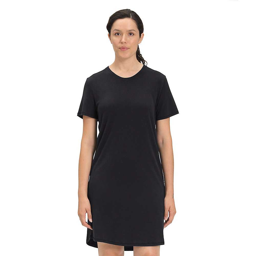 A woman with dark hair tied back stands against a plain white background, wearing The North Face Womens Best Tee Ever Dress— a simple, slim fit black dress with short sleeves.