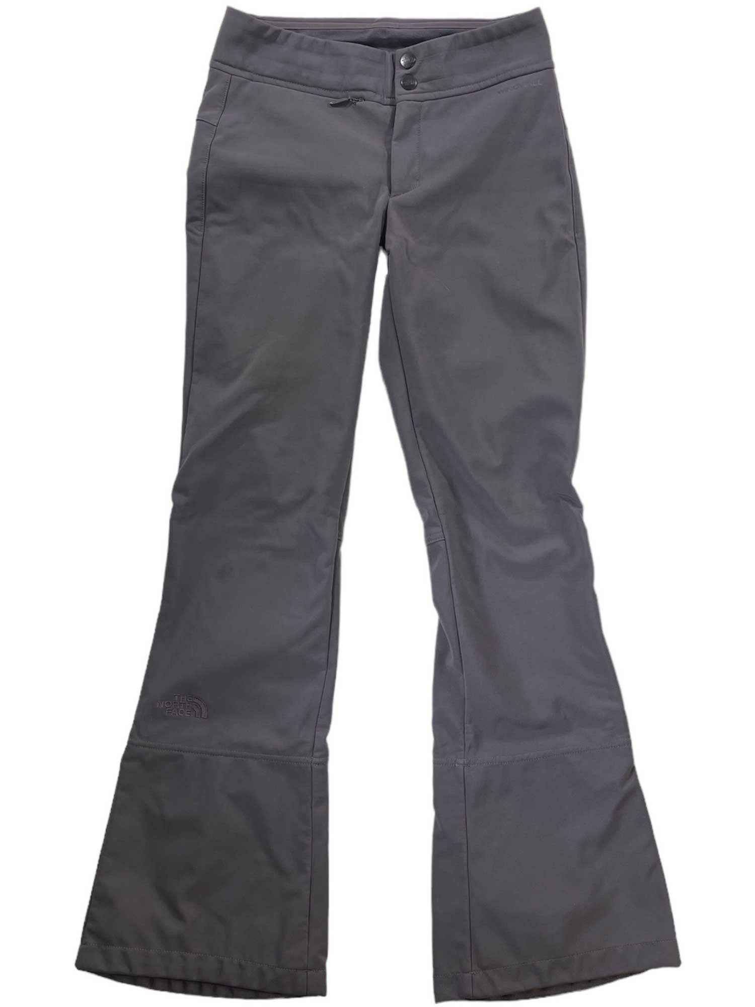 The Women's Snoga Snow Pants are gray, bootcut ski pants featuring a high-waist fit, button and zipper closure, ankle reinforcements, and subtle seam detailing, shown on a white background.