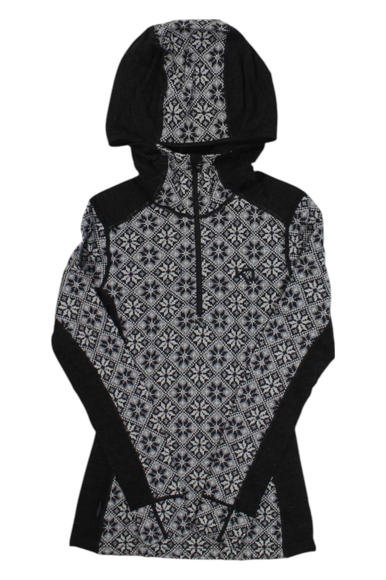 The Kari Traa Womens Rose Hood is a long-sleeve wool base layer with a black and white geometric snowflake pattern, front half-zip, hood, and black contrast panels on the shoulders and sides.