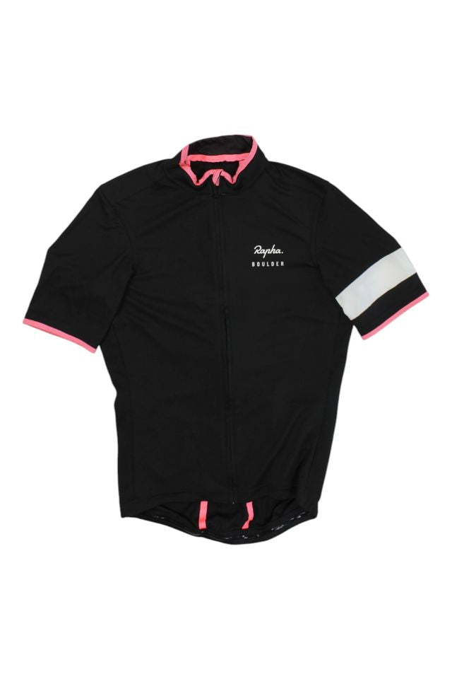 The Rapha Men's Super Lightweight Jersey is a black, short-sleeve cycling jersey with pink trim, a white horizontal stripe on the left sleeve, "Rapha Boulder" text on the chest, and a full front zipper.
