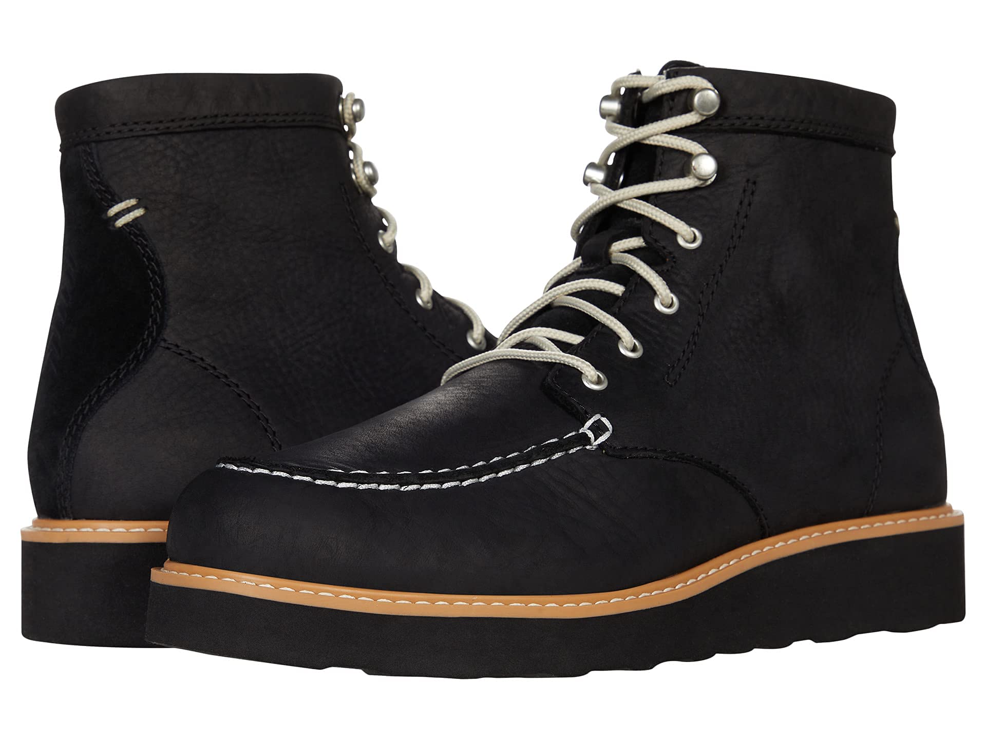 The Kodiak Scotia Black Moccasin Vamp Wedge Shoes feature black leather, a moccasin vamp design, white stitching, silver eyelets, light laces, and thick brown and black soles. One shoe faces forward as the other is angled to the side.