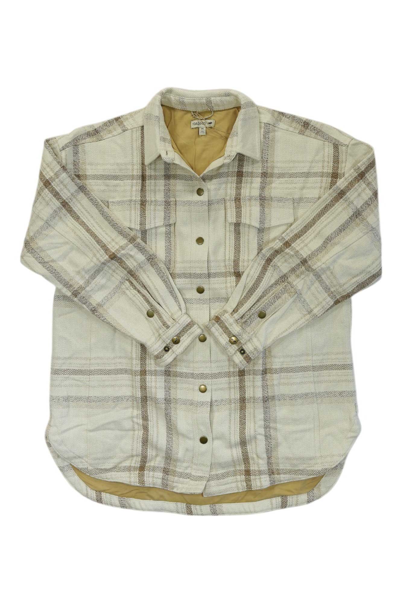 The Toad & Co Womens Conifer Shirt Jacket features a beige and light brown plaid design, long sleeves, two chest pockets, and a light tan lining. This versatile outerwear piece is shown laid flat on a white background.