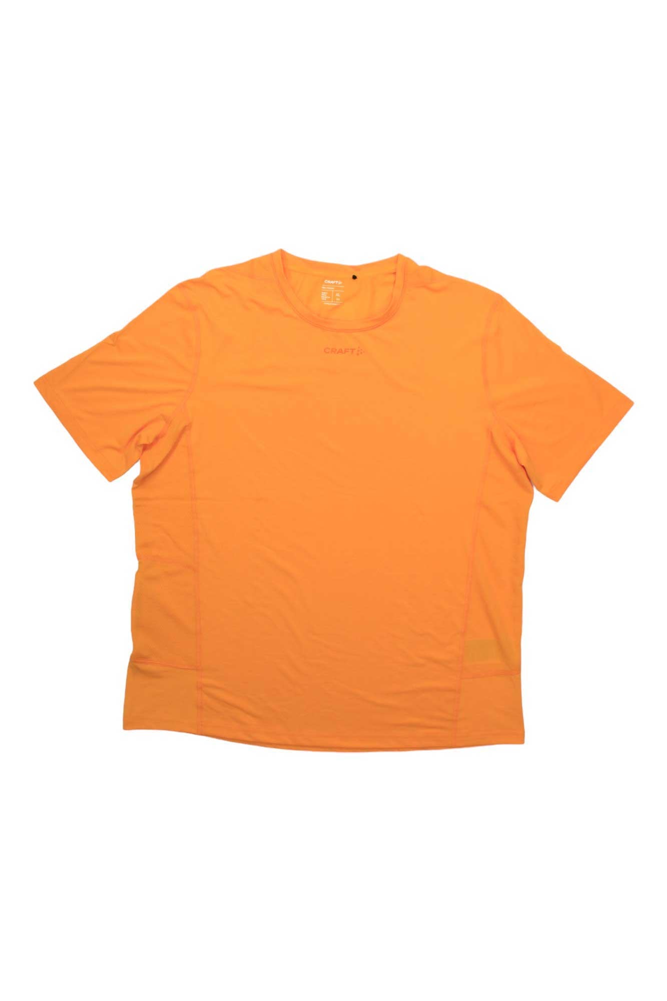 The Craft Sportswear Mens ADV Essence SS Tee is a plain, short-sleeved, bright orange crewneck shirt with moisture wicking fabric, minimal detailing, shown on a white background—perfect as a running tee for active lifestyles.