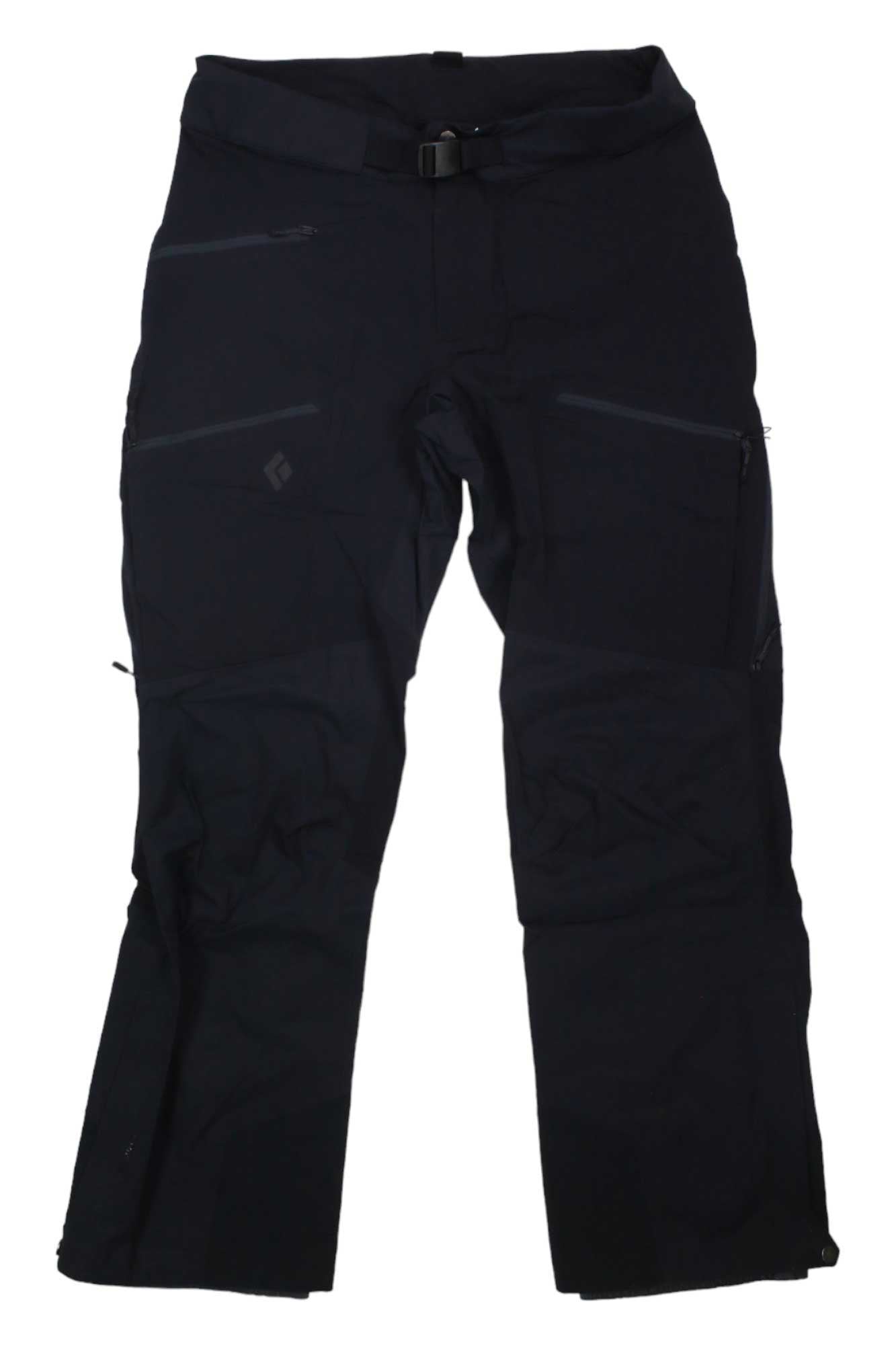 The Black Diamond Womens Dawn Patrol Hybrid Pant, in black, features breathable softshell material, multiple zippered pockets including an avalanche beacon pocket, a belted waist, and articulated knees. Ideal for hiking or climbing. Laid flat on white background.