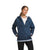 A woman stands against a white background wearing The North Face Womens Circaloft 1/4 Zip Pullover over a white shirt, hands in the pockets and a neutral expression on her face.