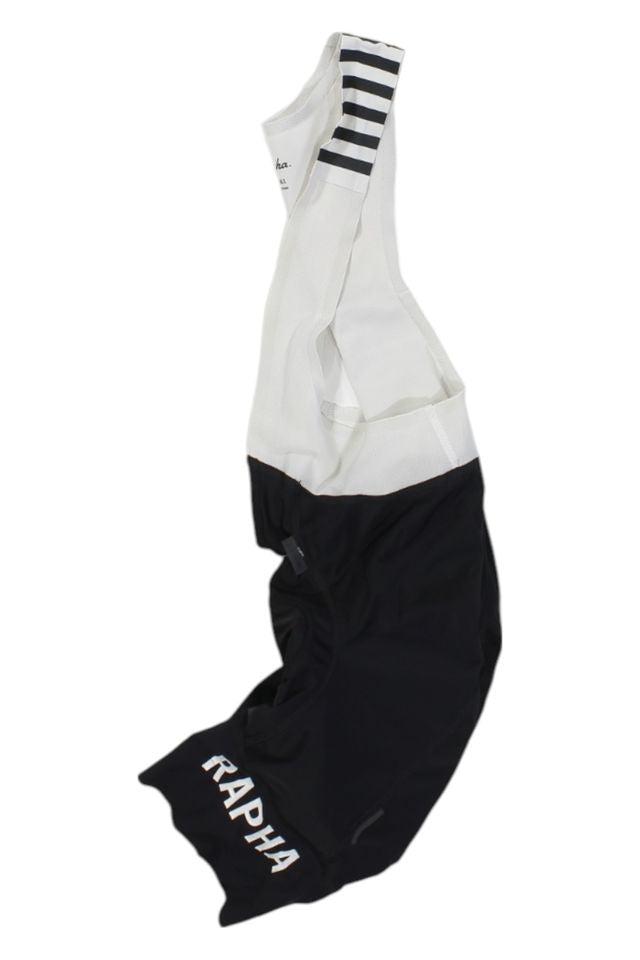 The Rapha Mens Pro Team Bib Shorts II - Regular feature white shoulder straps, black shorts with RAPHA in white on the left leg, and a race-grade chamois for superior comfort on long rides.