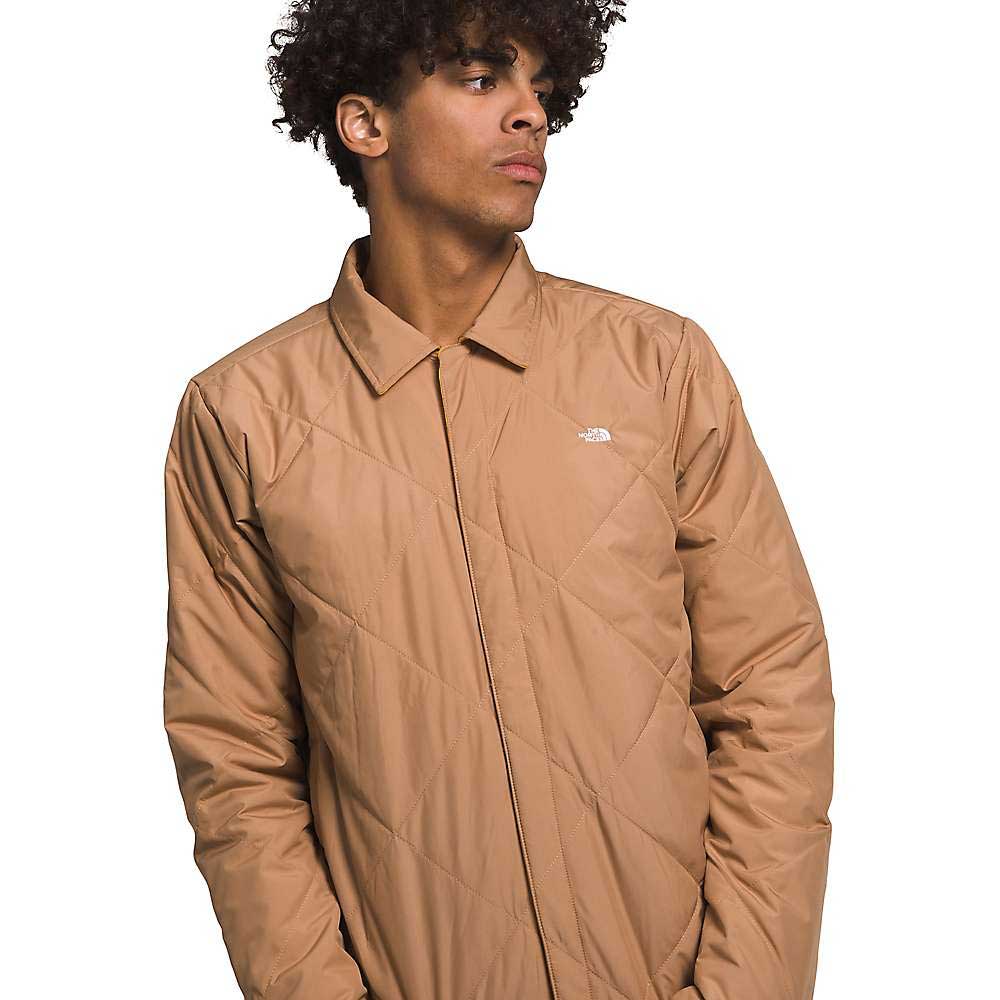 Men's quilted insulated jacket with front zipper, tan stand collar, and chest logo