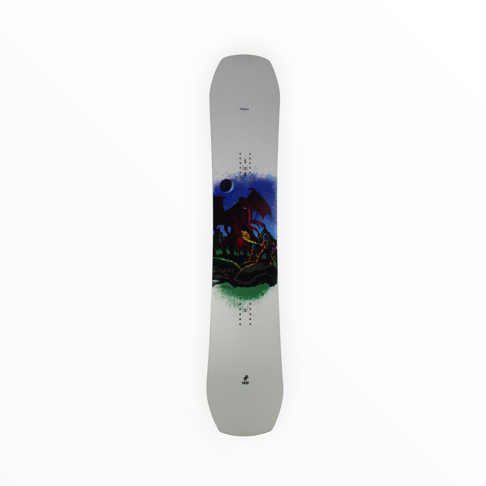 The YES Sender Snowboard showcases a red dragon soaring above a green rocky landscape under a dark moon on a white background. Its modern twin shape and camber-dominant profile deliver versatile all-mountain performance.