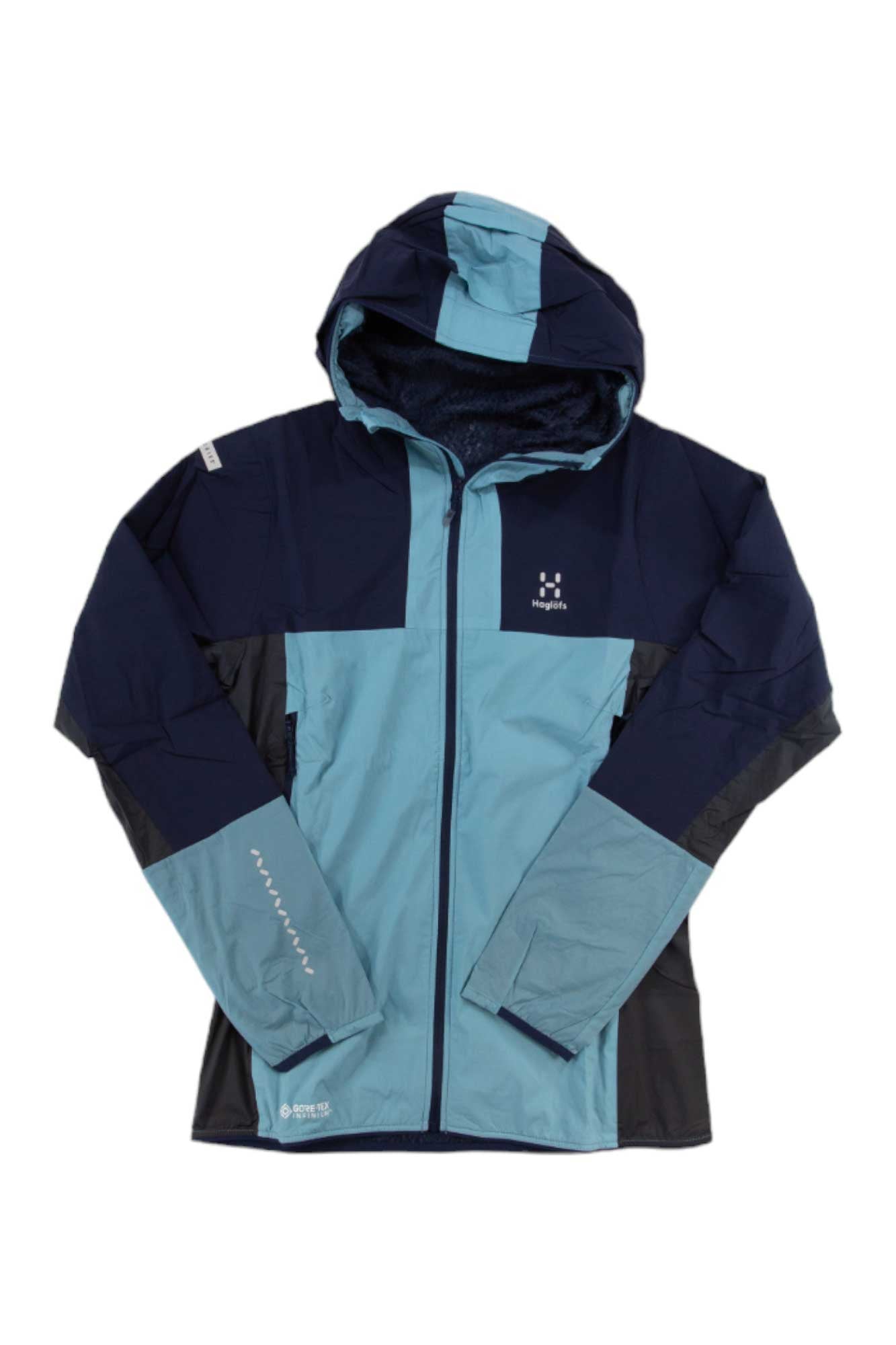 The Haglofs Womens L.I.M Alpha Hood is a two-tone outdoor jacket with a hood, dark navy and light blue panels, full front zipper, chest logo, and Polartec Alpha insulation for superior comfort during outdoor activities.