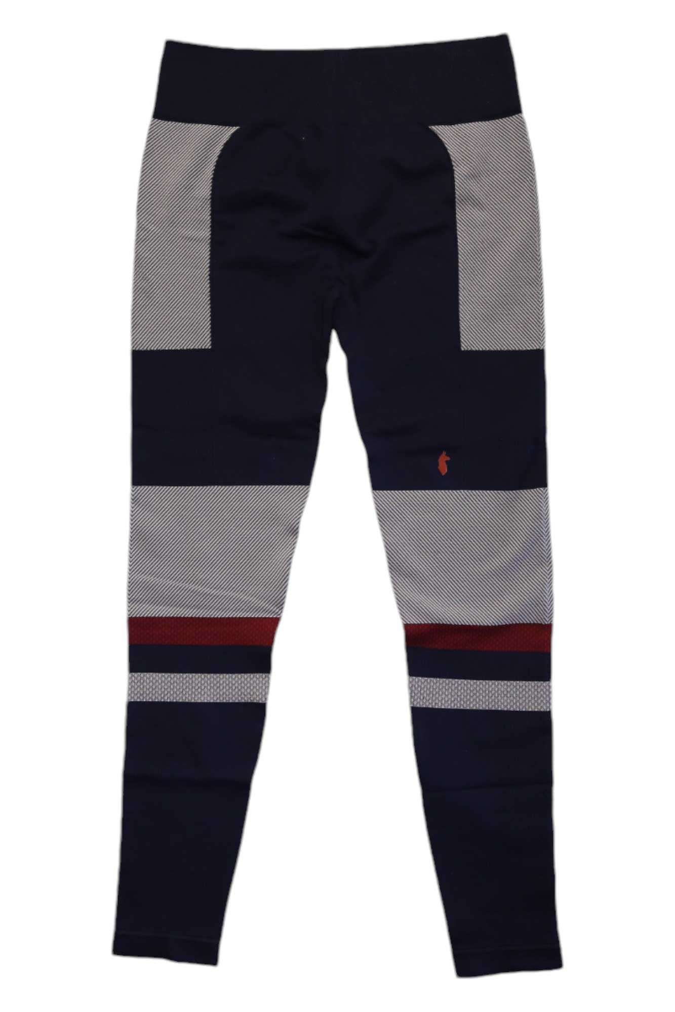 The Cotopaxi Womens Debajo Seamless Baselayer Tight features navy blue leggings with light gray panels, horizontal stripes, and a thin red knee stripe. Made from recycled materials, they have a small orange logo on the left thigh and are shown flat on a white background.