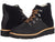 A pair of black suede Kodiak Sauveur Alpine Wedge Boots with orange and black laces, metal eyelets, and light brown stitched soles. One boot faces forward; the other is angled to display its side profile.