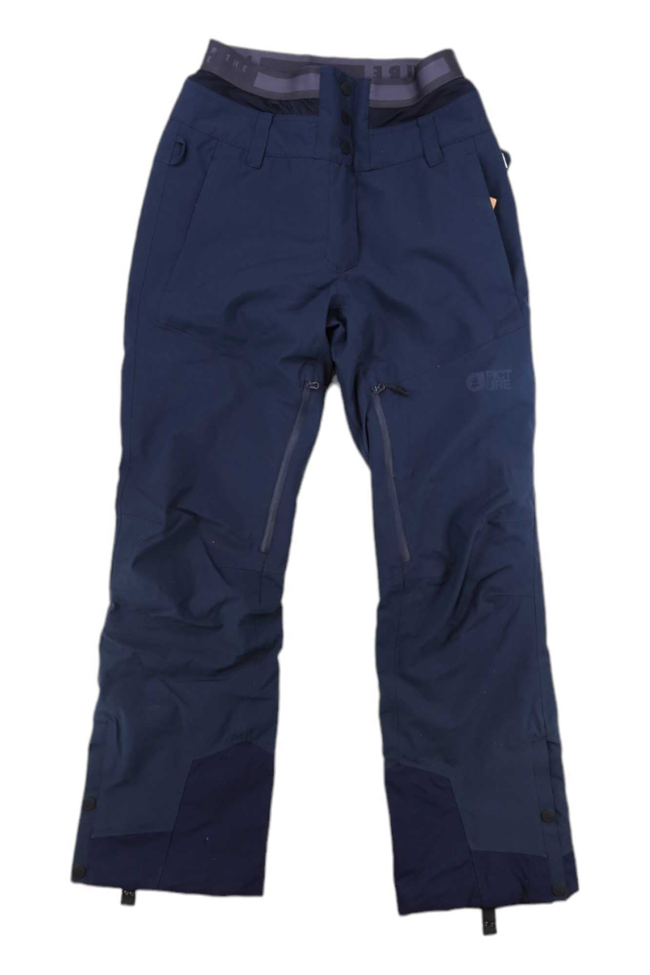 Picture Womens Exa Pant in navy blue, featuring button closure, front zippered pockets, reinforced cuffs, and adjustable waist tabs, displayed flat on a white background.