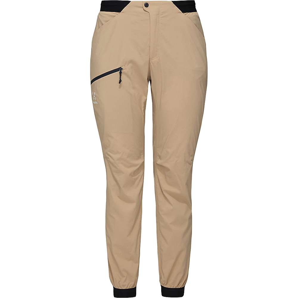 Beige athletic pants with black waistband and cuffs, featuring a side zip pocket and button waist closure—these breathable hiking pants are the Haglofs Womens L.I.M Fuse Pant, shown on a plain white background.