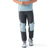 A person wearing Smartwool Men's Hudson Trail Fleece Pant in gray with light blue knee patches, a matching light blue shirt, and white athletic shoes stands with hands clasped. The photo shows the outfit from shoulders to feet.