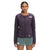 A woman stands facing forward in The North Face Womens Flight Ventrix Jacket, dark purple, with the logo visible, paired with green shorts against a plain white background.