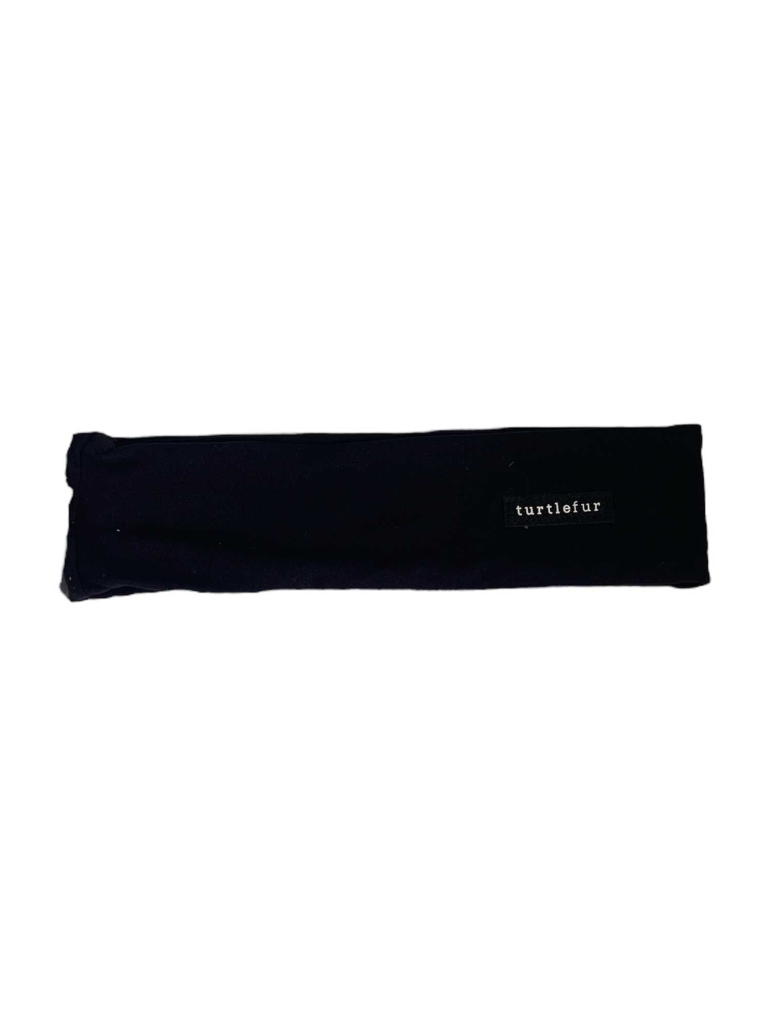 The Turtle Fur Comfort Shell Lite Supersoft Active Headband- Solid is a black, rectangular, moisture-wicking headband featuring a small white Turtle Fur logo in the lower right corner, shown on a plain white background.