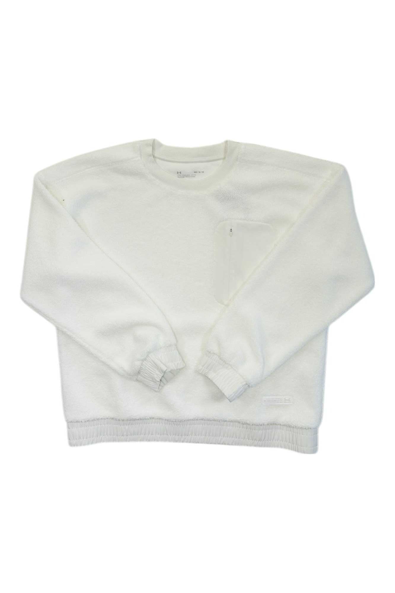 The Under Armour Womens Mission Boucle Crew is a plain white long-sleeve crewneck sweatshirt with a small chest pocket and elastic cuffs and hem, ideal for outdoor layering, shown laid flat on a white background.