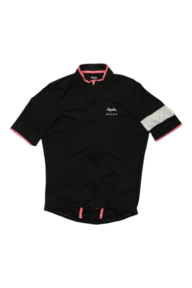 The Rapha Mens Super Lightweight Jersey is a black, short-sleeve cycling top with pink trim, a white stripe on the left sleeve, front zipper, and features the Rapha logo and RIDERS text on the left chest.