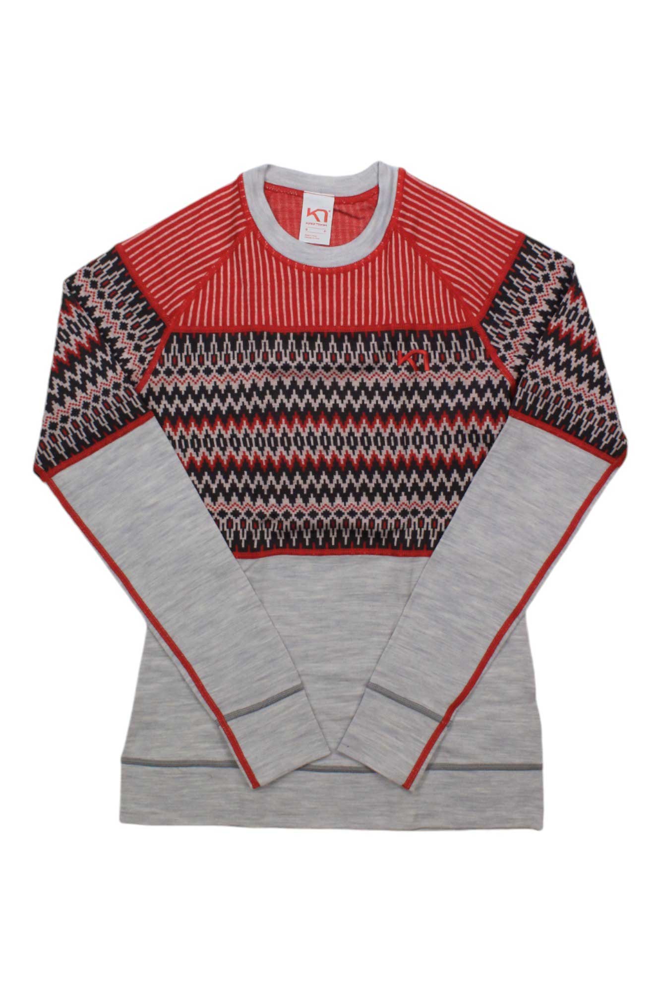 The Kari Traa Women's Silja LS Top is a long-sleeve knit sweater with a red and black geometric zigzag design on the chest and shoulders, light gray sleeves and body—ideal as a merino wool base layer or stylish cold weather top.