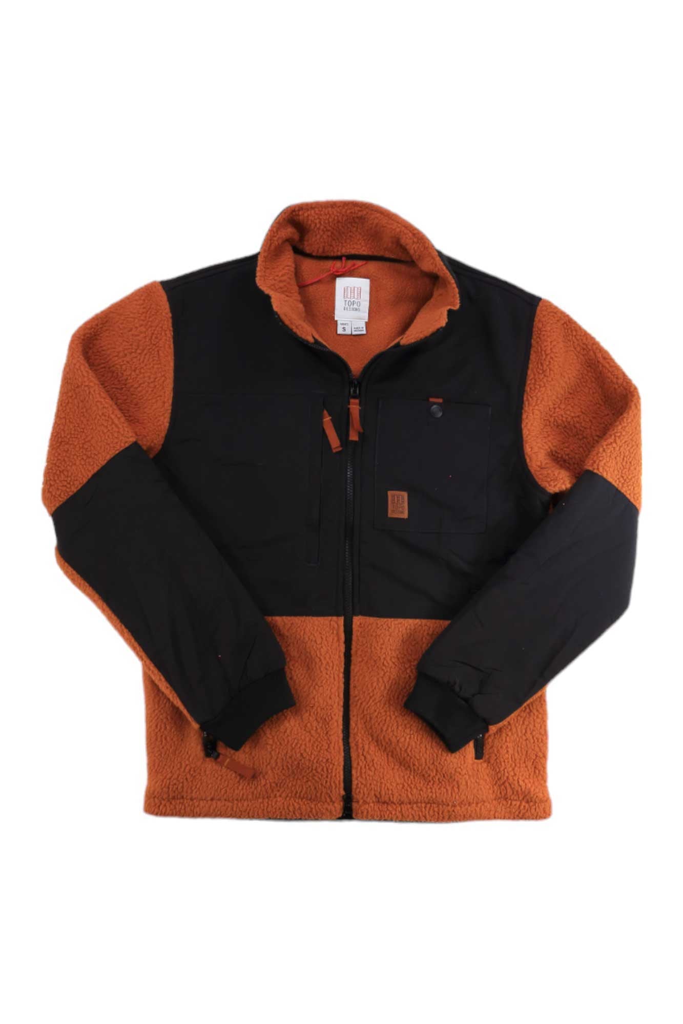 The Topo Designs Mens Subalpine Fleece Jacket features a rust-orange Polartec fleece body with black panels on the chest, sleeves, and shoulders. Details include a high collar, front zipper, zip pockets, and Topo Designs logo patch.