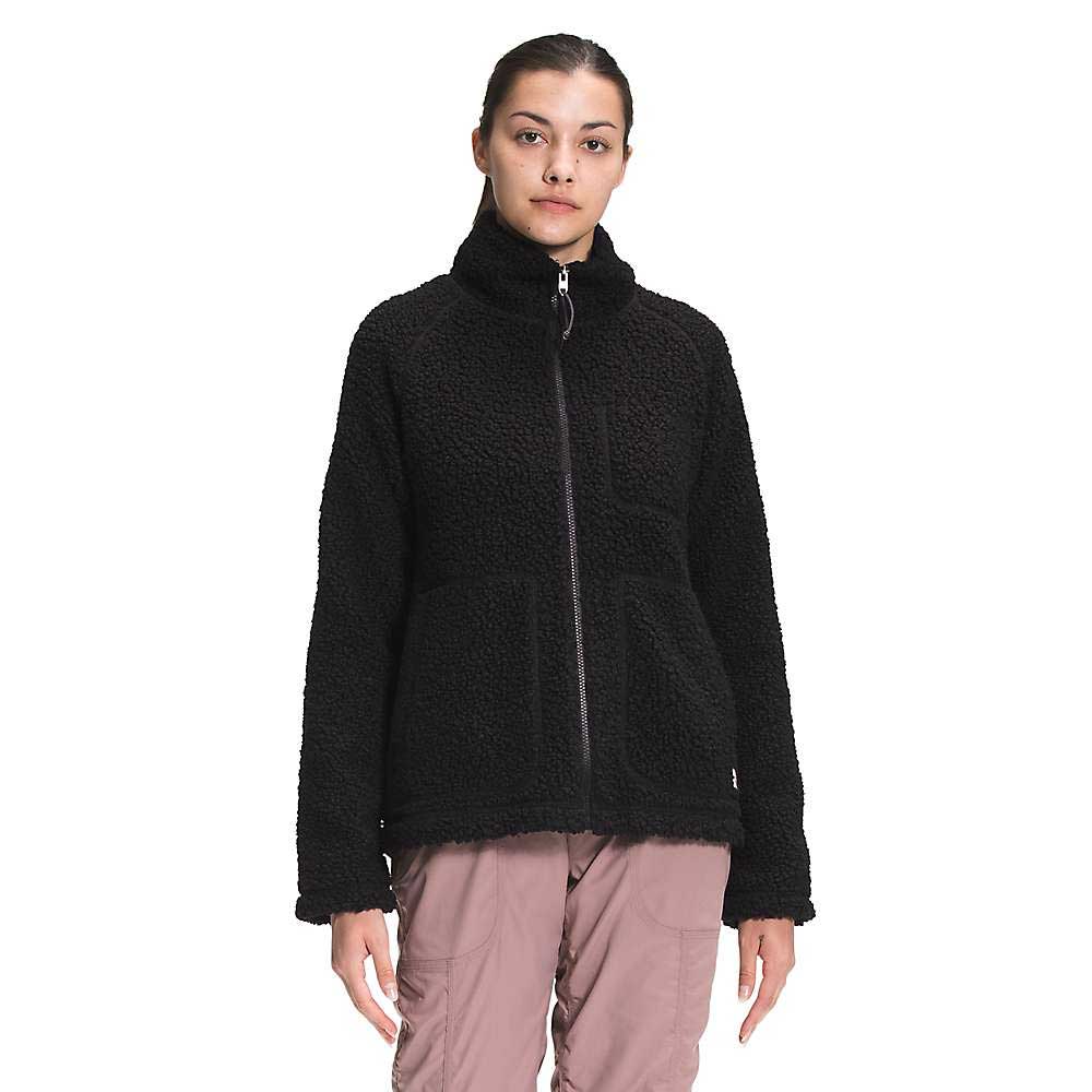 A woman wearing The North Face Womens Ridge Fleece Full Zip Jacket in black and light brown cargo pants stands facing forward against a plain white background.