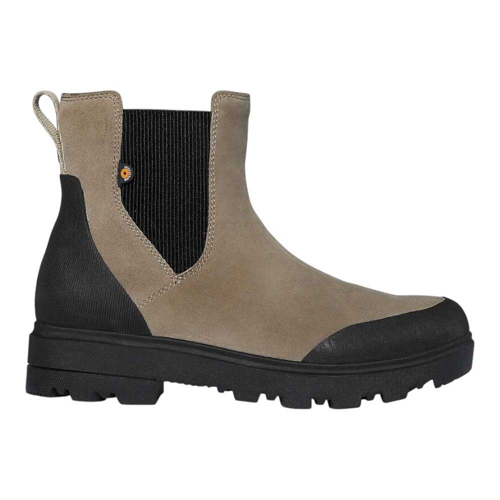 The Bogs Womens Holly Chelsea Leather Boot features taupe suede, black elastic panels, a heel pull tab, black overlays on toe and heel, and a chunky black rubber sole for a rugged, eco-friendly look.